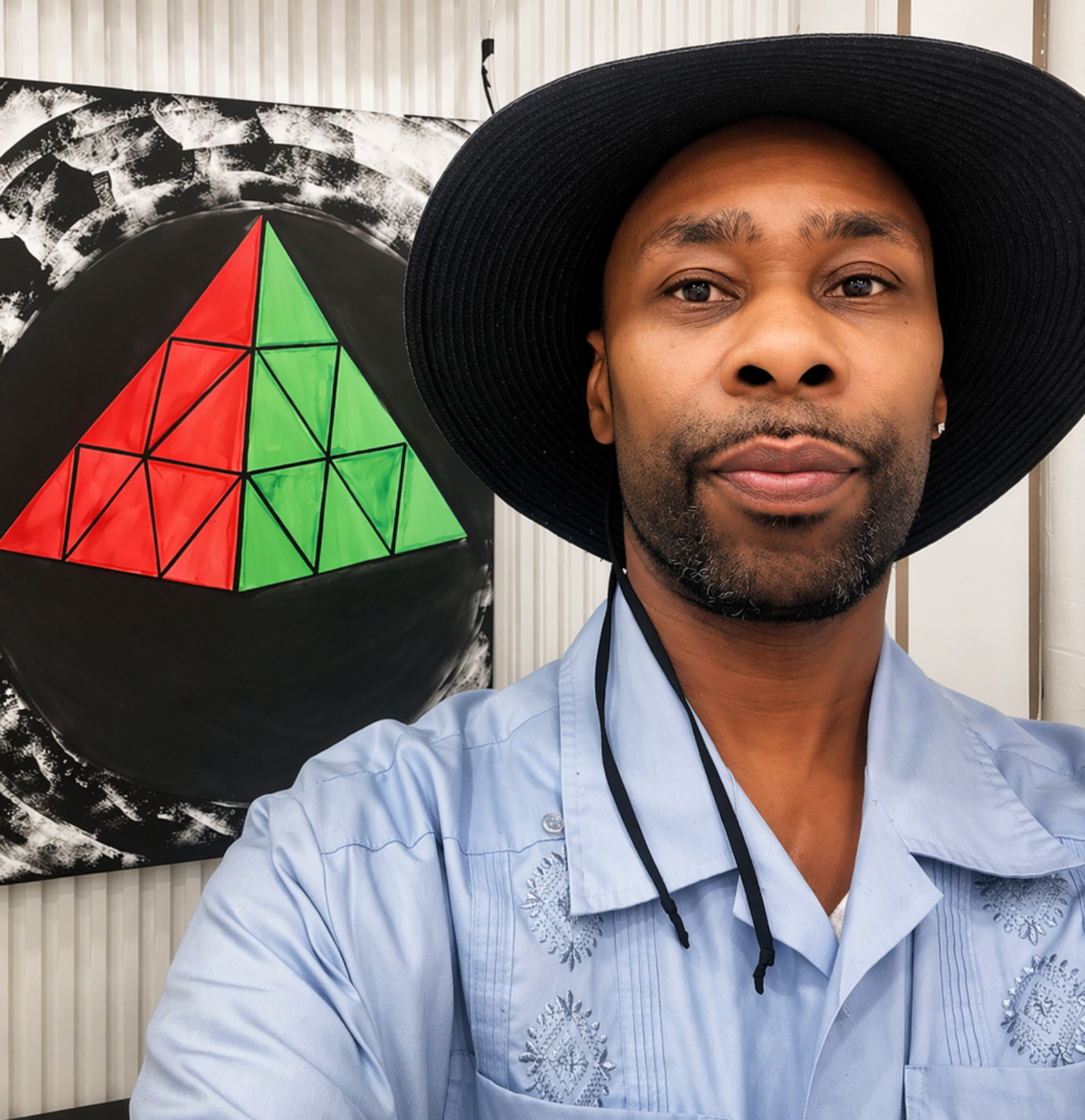 Dinco D portrait in front of geometric artwork